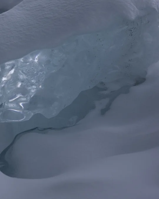 Right half of the same blue ice formation meeting snow