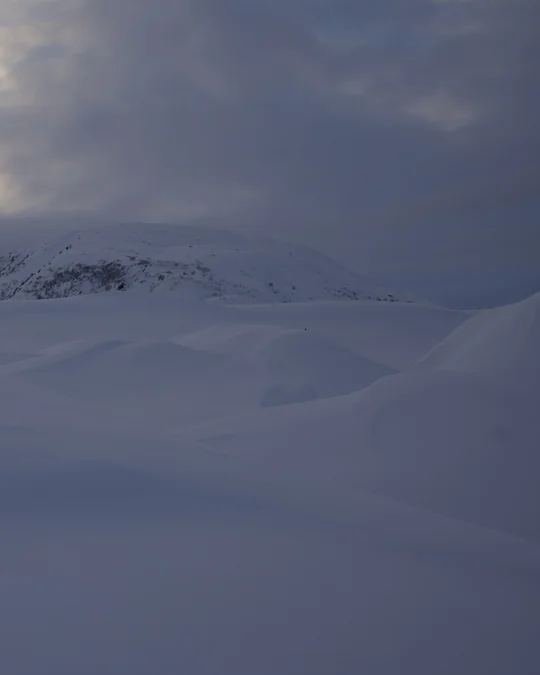 Right half of the same snowy landscape and distant ridge